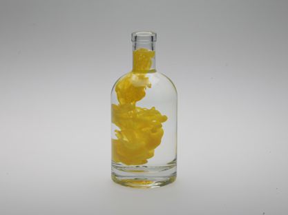 Photography - floating yellow color in water in glass bottle