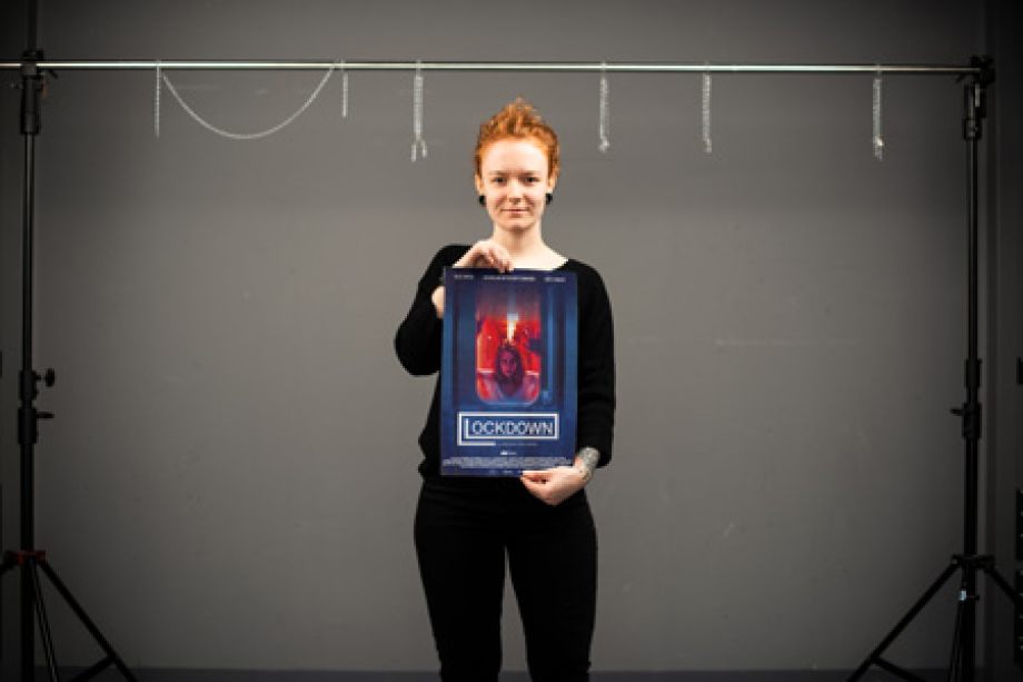 Photography of Nina Lesznik holding a "Lockdown" Film poster