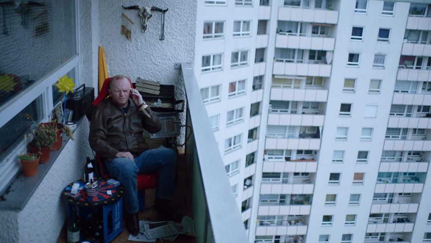Screenshot from "Zahltag" showing the main character siting on his balcony