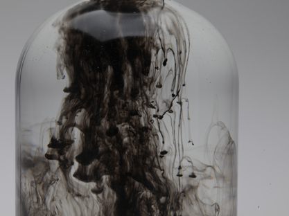 Photography - floating black color in water in glass bottle