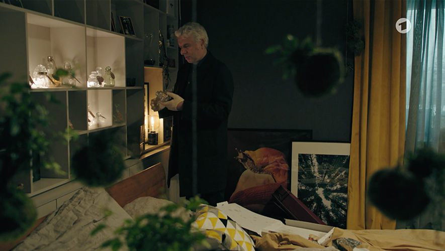 Screenshot from "Tatort Dreams" showing the main character looking on a glass