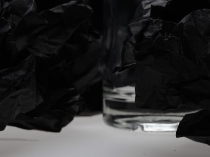 Photography - close-up of glass bottle in between black paper